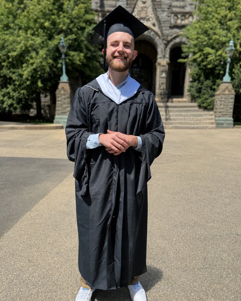 Caleb Johnston in master’s graduation regalia at Georgetown.