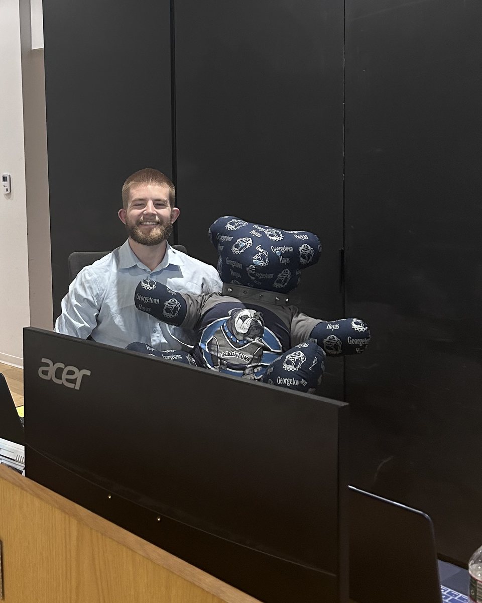 Caleb Johnston at the PJI front desk beside a Georgetown bulldog mascot.